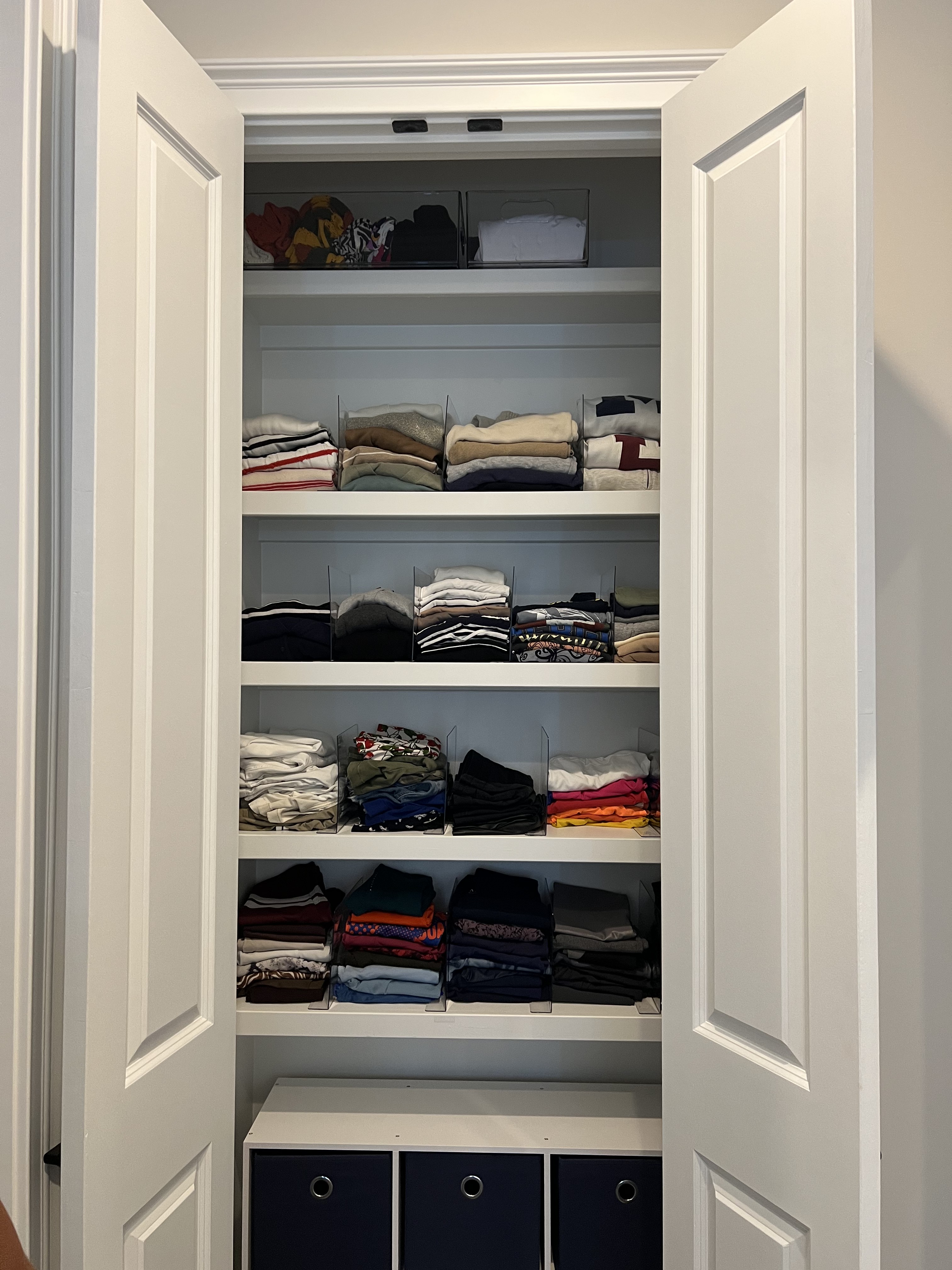 The same closet after the session, with folded clothes neatly arranged on open shelving