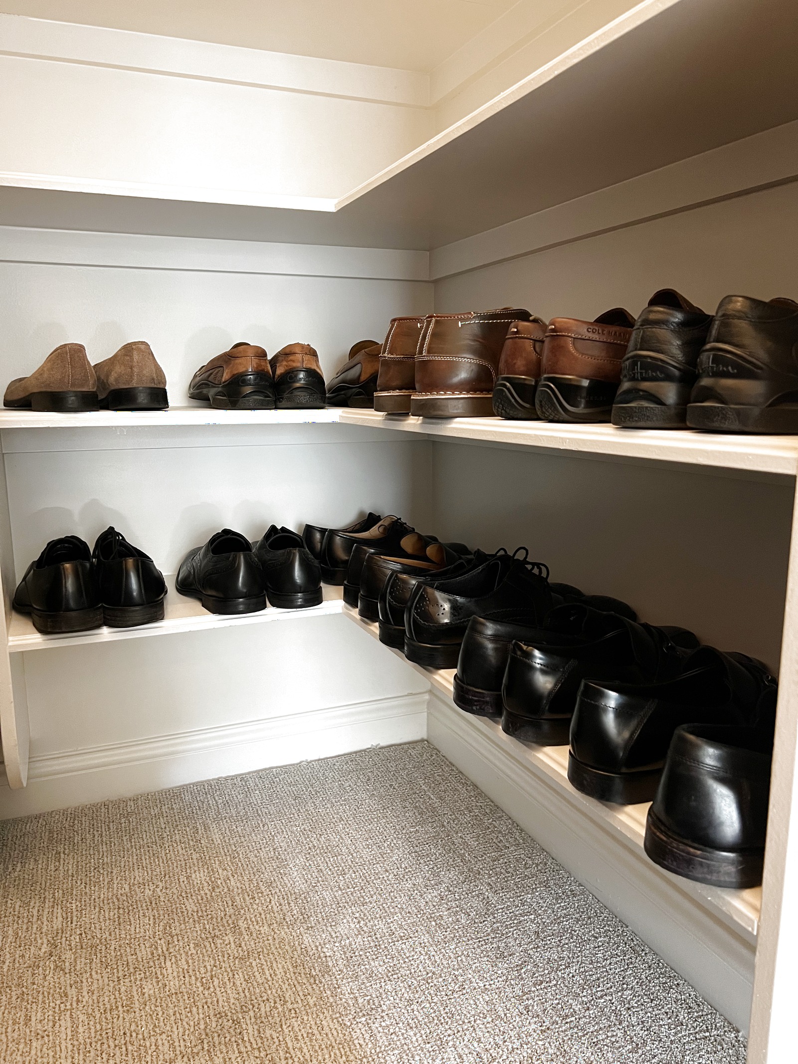 Professional menswear shoe shelves organized by color
