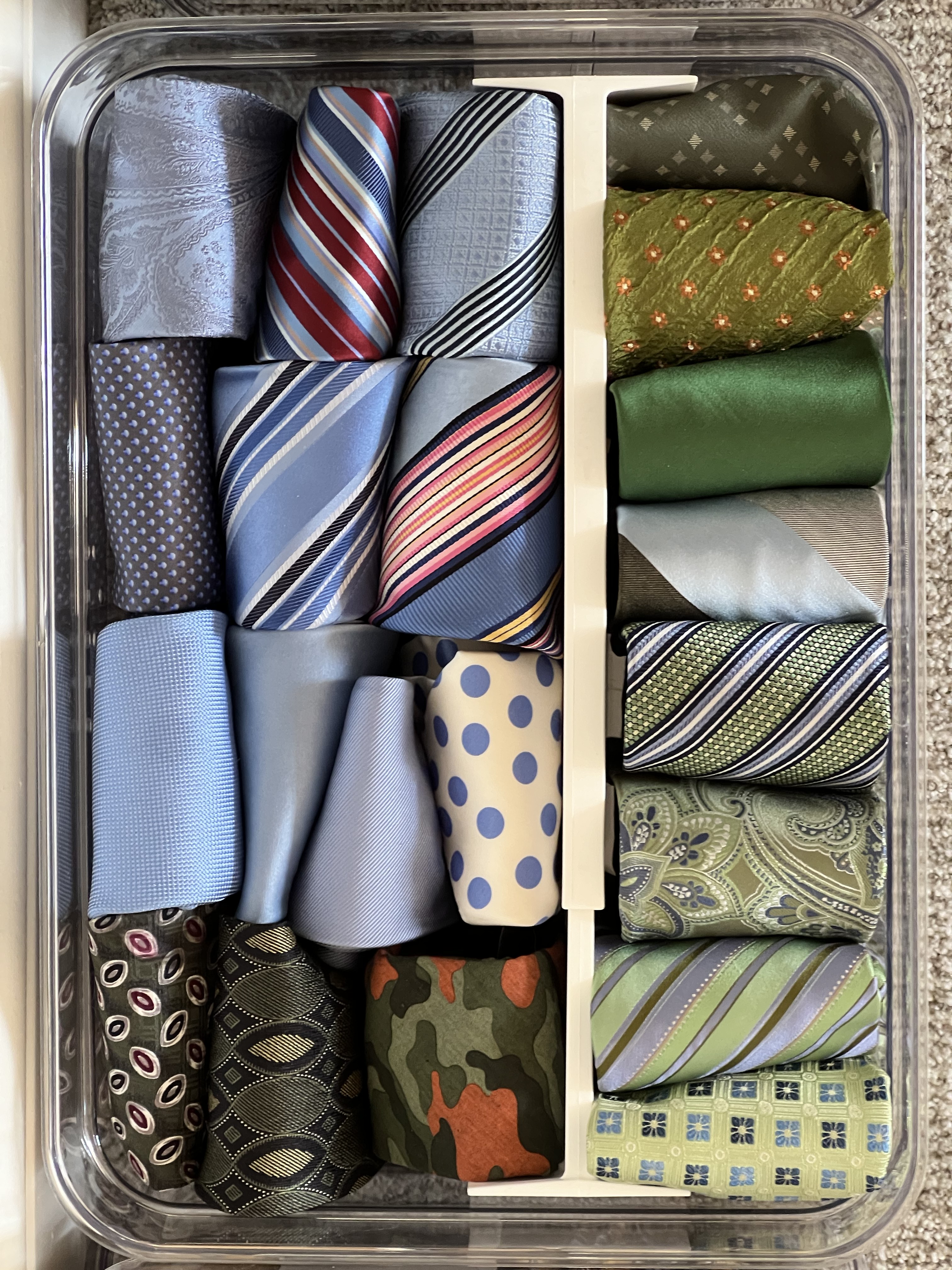 Neatly rolled ties organized in a divided drawer